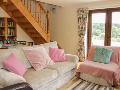 a living room with a couch and two chairs at Minton Lane Cottage in Church Stretton