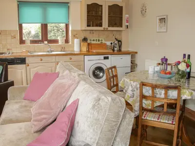 a kitchen with a couch and a table in a kitchen at Minton Lane Cottage in Church Stretton