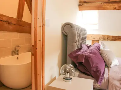 a bathroom with a bed and a sink and a tub at Broughton Stables in Montgomery