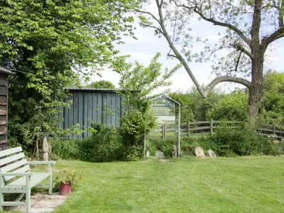 a garden with a bench and a fence at Broughton Stables in Montgomery