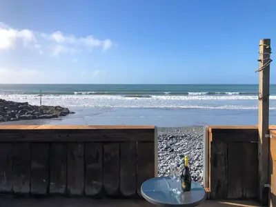 a bottle of wine sitting on a table on the beach at Ystwyth House in Borth