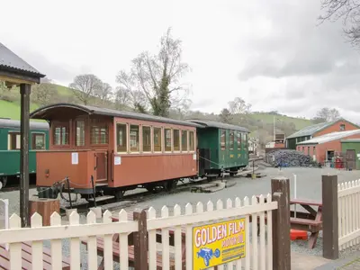 a train on the tracks next to a fence at The Rhiw in Newtown