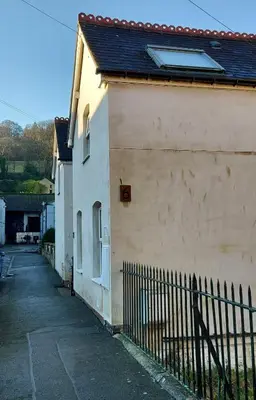 a white building with a fence next to it at The Holt in Llangollen