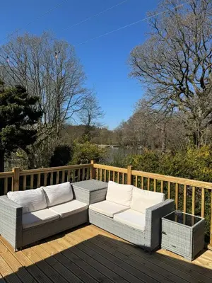 a patio with two couches on a wooden deck at 8F Lakeside Lodge Caer Beris Builth Wells - No Tradesman in Builth Wells
