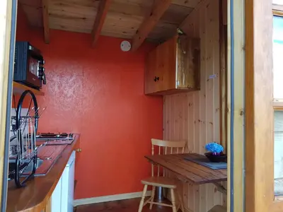 a kitchen with orange walls and a wooden counter top at Cozy Cabin Retreat - Sleeps 2 & a Child in Craven Arms