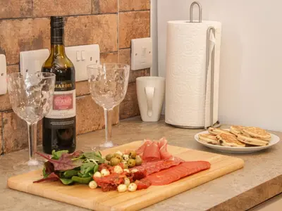 a cutting board with meat and vegetables and wine glasses at Conquer Hall in Montgomery