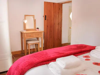 a bedroom with a bed with a red blanket and a mirror at Conquer Hall in Montgomery