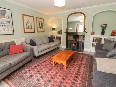 a living room with two couches and a fireplace at Cwmalis Hall in Llangollen