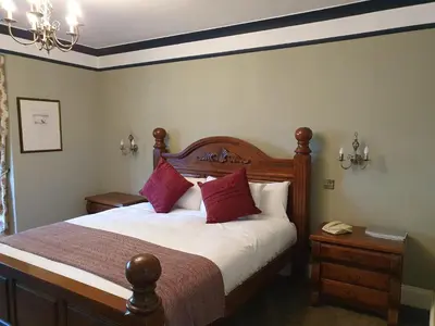 a bedroom with a large bed with red pillows at The Radnorshire Arms Hotel in Presteigne