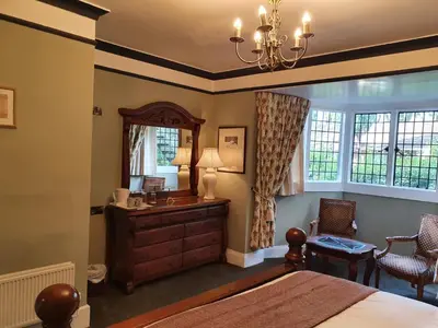 a bedroom with a bed and a dresser and a mirror at The Radnorshire Arms Hotel in Presteigne