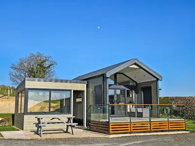 a tiny house with a picnic table in front of it at Lake Vyrnwy Luxury Pod in Llanwddyn
