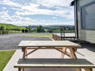 a wooden picnic table sitting outside of a building at Lake Vyrnwy Luxury Pod in Llanwddyn