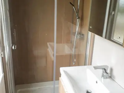 a shower with a glass door next to a sink at Lake Vyrnwy Luxury Pod in Llanwddyn