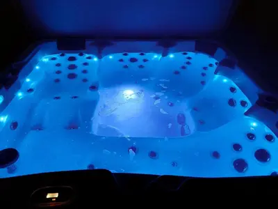 a blue hot tub in a dark room at Lake Vyrnwy Luxury Pod in Llanwddyn