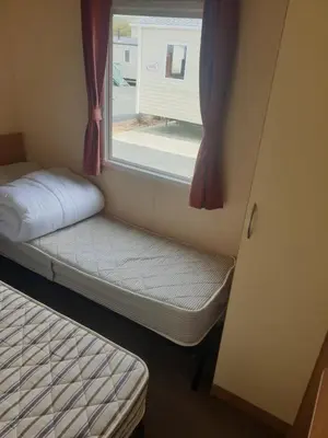 a small room with a window and a bed at Hill View caravans in Aberystwyth