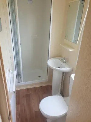 a bathroom with a toilet and a sink and a shower at Hill View caravans in Aberystwyth