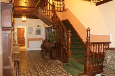 a hallway with a staircase in a house at Cae'r Blaidd Country House in Ffestiniog