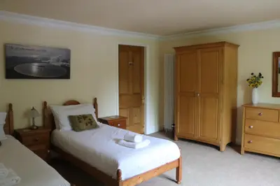 a bedroom with two beds and a dresser at Cae'r Blaidd Country House in Ffestiniog