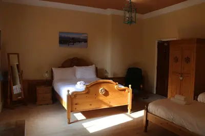 a bedroom with a bed and a dresser in a room at Cae'r Blaidd Country House in Ffestiniog