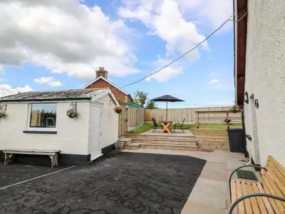 a backyard with a shed and a picnic table at Green Cottage in Rhayader