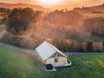 an old cabin in a field with the sunset in the background at Oak View in Highgate