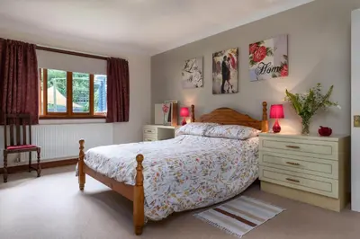 a bedroom with a bed and a dresser at Finest Retreats - The Grove Annexe in Craven Arms