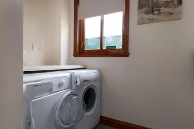 a washing machine in a room with a window at Finest Retreats - The Grove Annexe in Craven Arms