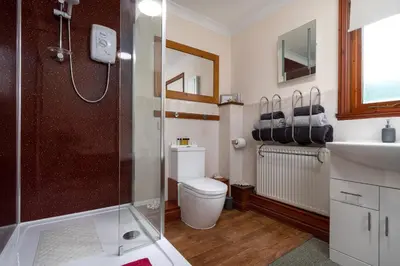 a bathroom with a shower and a toilet and a sink at Finest Retreats - The Grove Annexe in Craven Arms