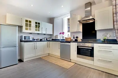a kitchen with white cabinets and stainless steel appliances at 3 Bed in Tywyn oc-bow170 in Tywyn