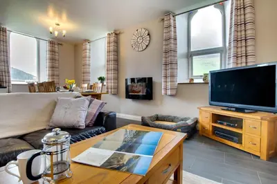 a living room with a couch and a flat screen tv at 3 Bed in Tywyn oc-bow170 in Tywyn