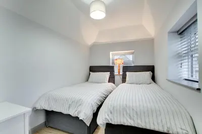 two beds in a room with white walls and a window at 5 Bed in Bala oc-bow163 in Bala