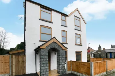 a white house with a wooden fence at 5 Bed in Bala oc-bow163 in Bala