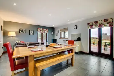 a dining room and living room with a wooden table at 3 Bed in Bala oc-bow162 in Bala