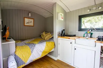a small bedroom with a bed and a sink at Woodpeckers in Llandrindod Wells