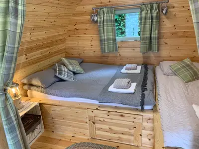 a log cabin with two beds in it at Torrent Walk Glamping Huts in the Heart of Snowdonia in Dolgellau