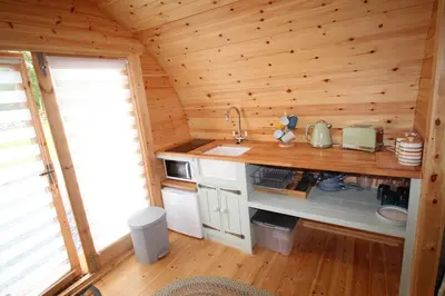 a kitchen in a log cabin with a sink at Torrent Walk Glamping Huts in the Heart of Snowdonia in Dolgellau