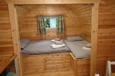 a room in a log cabin with a bed in it at Torrent Walk Glamping Huts in the Heart of Snowdonia in Dolgellau
