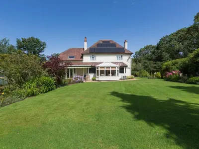 a large house with a large lawn in front of it at The Big Dingle in Church Stretton