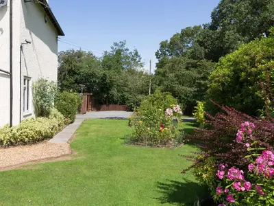 a garden with pink flowers and a house at The Big Dingle in Church Stretton