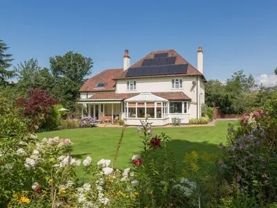 a large white house with a solar roof at The Big Dingle in Church Stretton