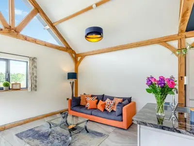 a living room with an orange couch and a table at The Hideaway in Highgate