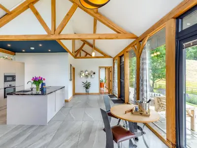 a kitchen with wooden ceilings and a table and chairs at The Hideaway in Highgate