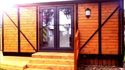 a wooden cabin with a purple door and stairs at the cwch in Llanbister