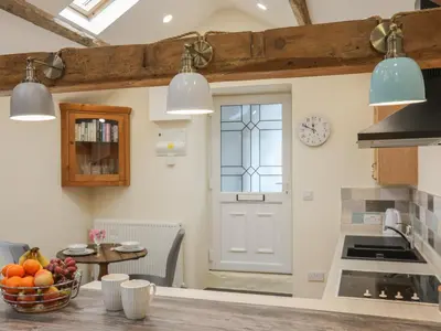 a kitchen with a door and a table with fruits at Glan Meon Cottage in Barmouth