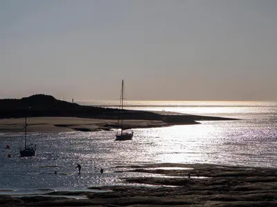 two boats sitting in the water on the beach at Glan Meon Cottage in Barmouth
