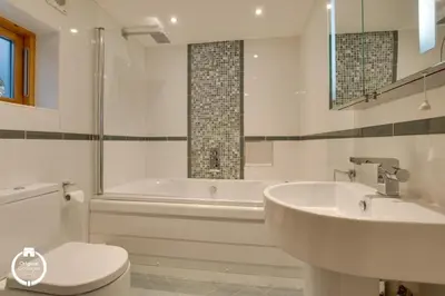 a bathroom with a tub and a sink and a toilet at The Old Stables Aberdyfi apartment 3 in Aberdyfi