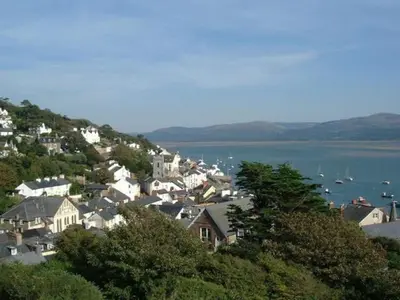 a town on a hill with boats in the water at The Old Stables Aberdyfi apartment 6 in Aberdyfi