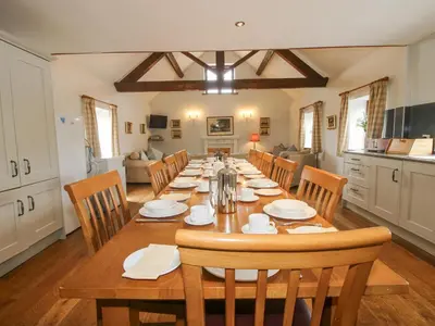 a dining room with a long table and chairs at The Onibury in Craven Arms