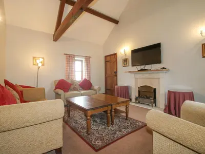 a living room with a table and a fireplace at The Onibury in Craven Arms