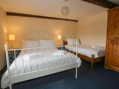 a bedroom with two beds and two lamps at The Walton in Craven Arms